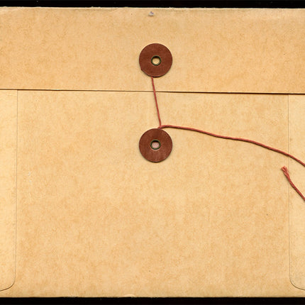 Brown paper envelope with string closure on a matching brown background