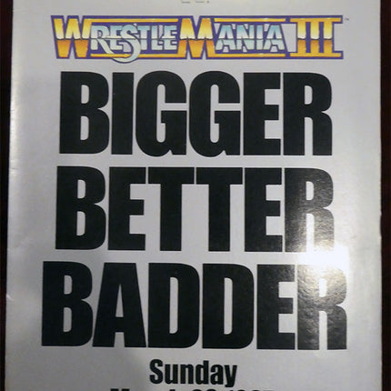 Promotional kit for WrestleMania III with text 'Bigger Better Badder' and event details.